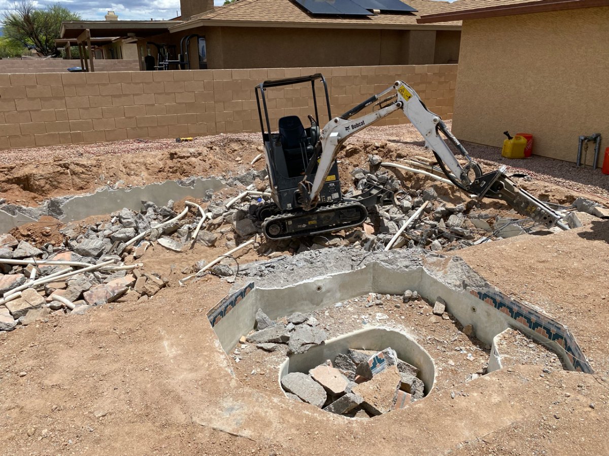 Broken concrete placed in the bottom of a pool being filled